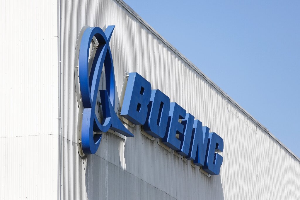 Boeing reports surprise profit and says it will cut fewer jobs