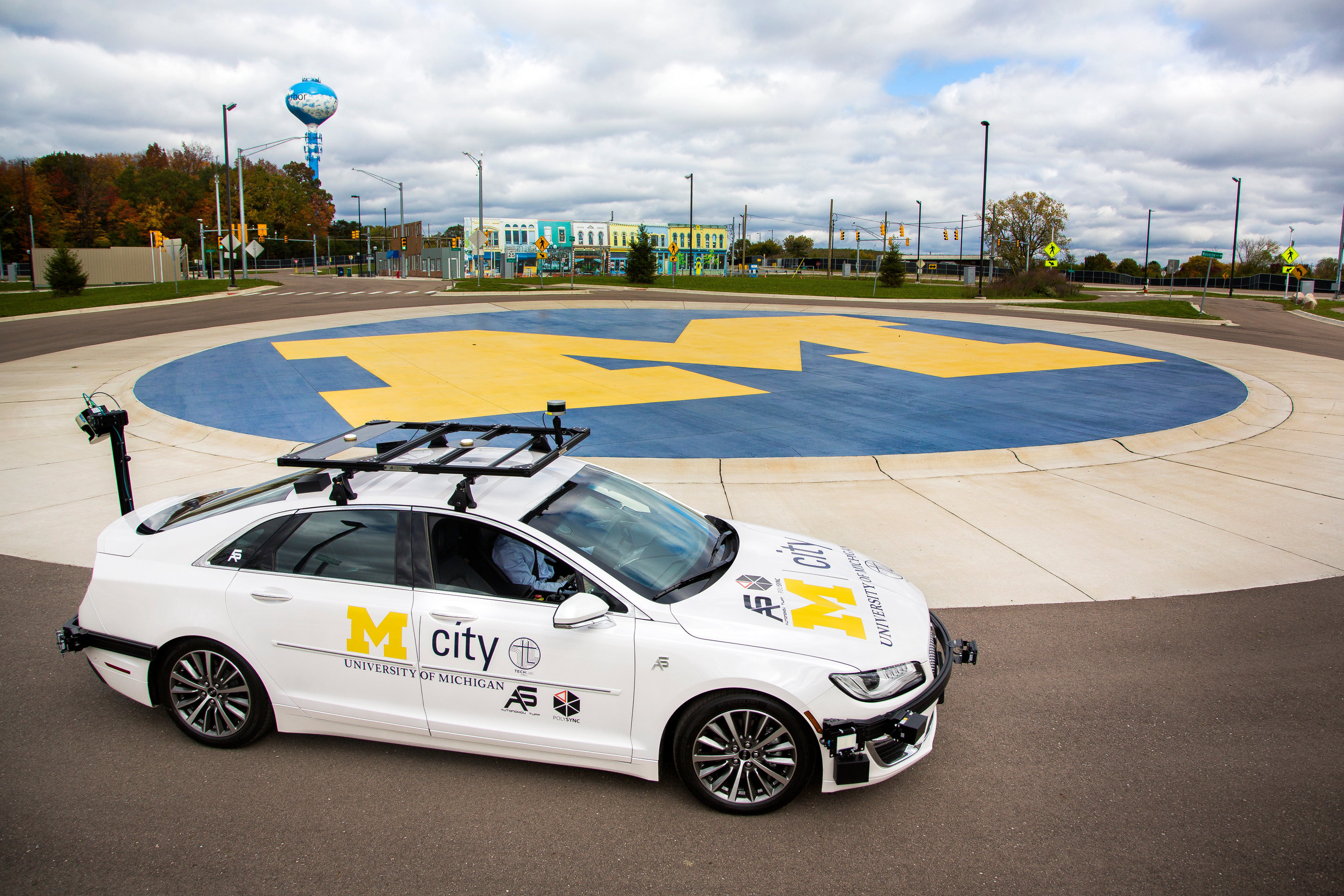  A self-driving car drives around a roundabout, demonstrating the benefits of autonomous vehicles, such as increased safety, efficiency, and mobility.