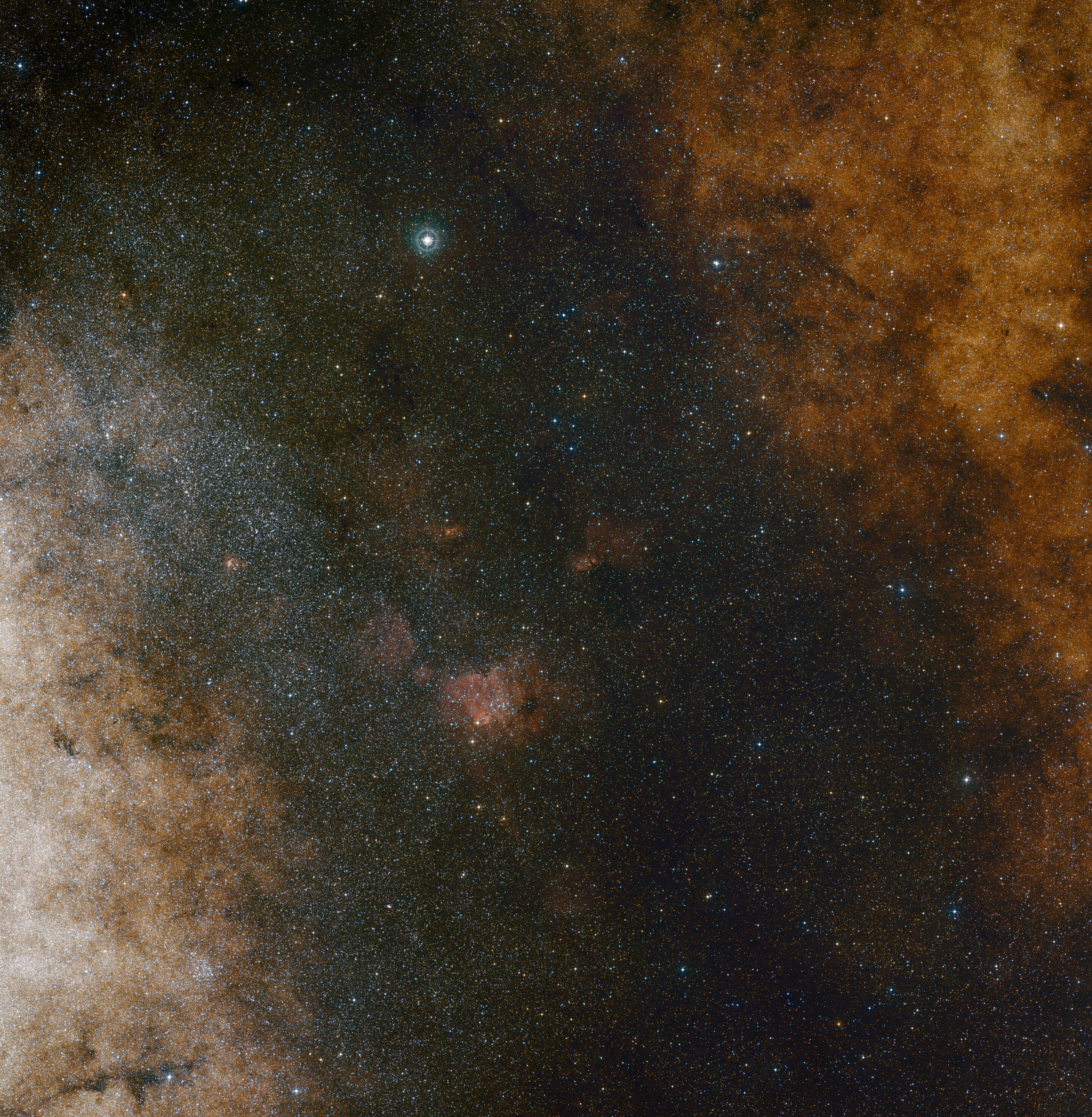 Essa visão de campo amplo de luz visível mostra as ricas nuvens de estrelas na constelação de Sagitário (o Arqueiro) na direção do centro da nossa galáxia Via Láctea. A imagem inteira está repleta de um grande número de estrelas, mas muitas outras permanecem ocultas atrás de nuvens de poeira e só são reveladas em imagens infravermelhas. Essa visualização foi criada a partir de fotografias em luz vermelha e azul e faz parte do Digitized Sky Survey 2. O campo de visão é de aproximadamente 3,5 graus x 3,6 graus. Crédito: ESO e Digitized Sky Survey 2. Agradecimentos: Davide De Martin e S. Guisard