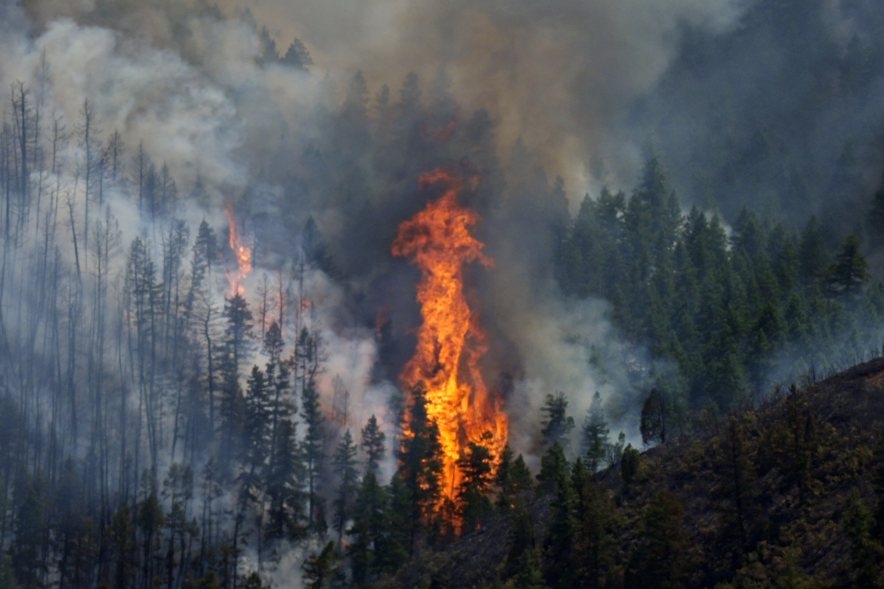 Wildfires encroach on homes near Denver as heat hinders fight